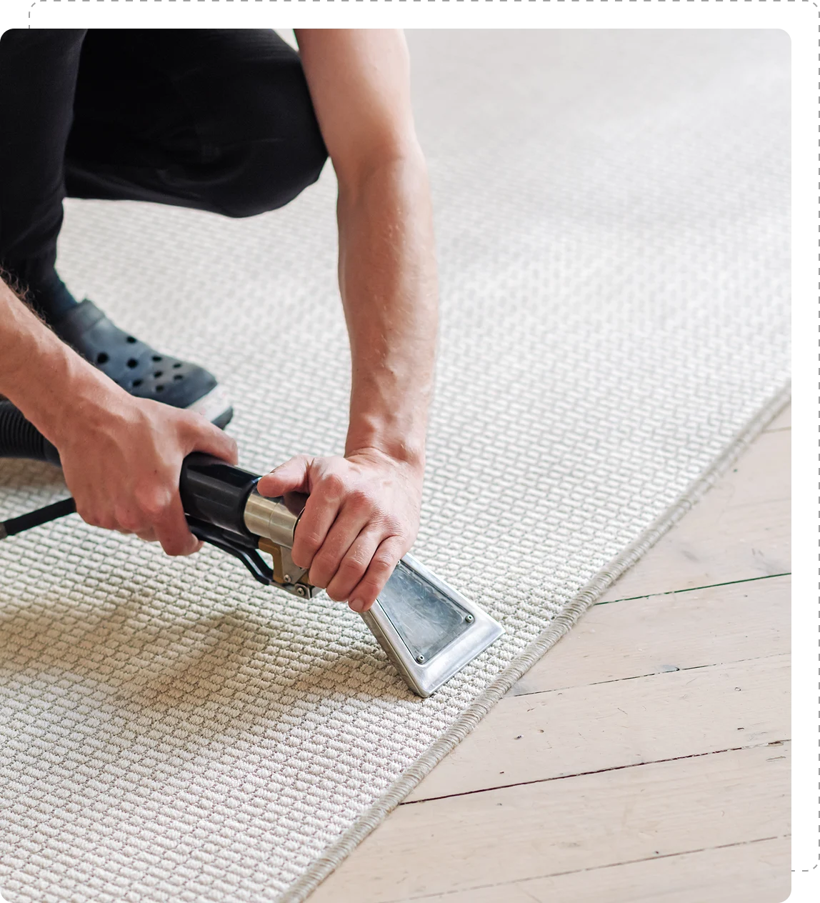 Person cleaning carpet with a vacuum tool.