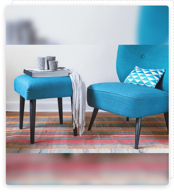 Blue armchair with a matching ottoman and a cozy throw in a stylish living room.